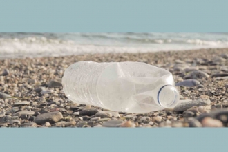 Empty bottle lying on stoney beach