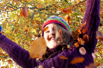 Girl throwing autumn leaves in the air
