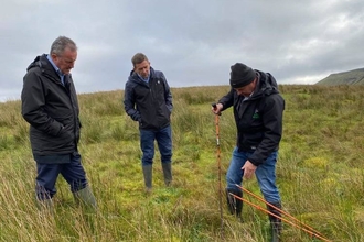 Connor Murphy watching Jim McAdam peat coring on Cuilcagh 