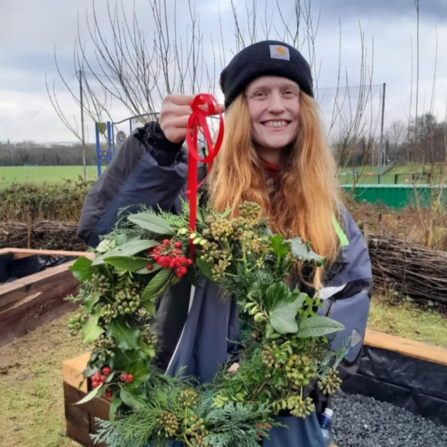 Close up of Amber Jennings, a young conservation hero, holding up a Christmas wreath
