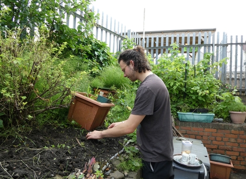 Student works on a planting bed in a community garden. 