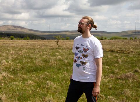 Model wearing Ulster Wildlife men's butterflies t-shirt in white colour and looking left into the distance